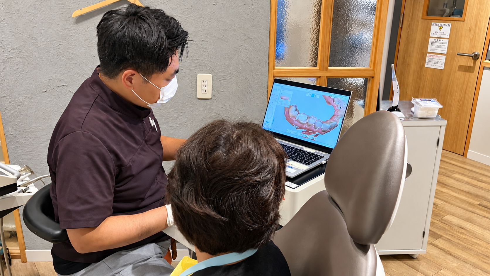 歯科医師が口腔内スキャンの画像を見ながら治療について説明するカウンセリング風景